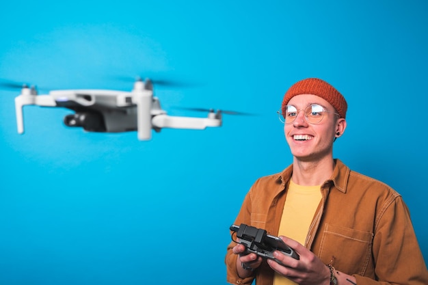 Un joven sonriente entrenando para pilotar un avión no tripulado en vuelo con un control remoto