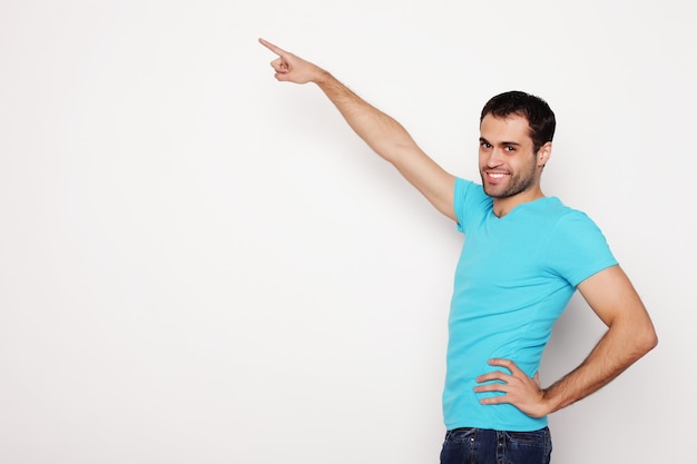 Joven sonriente feliz hombre muestra algo