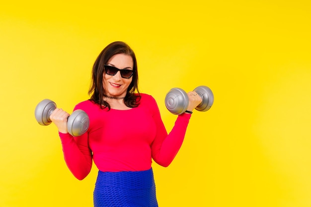 Joven sonriente feliz regordeta sobrepeso más tamaño gran grasa mujer en forma calentarse entrenamiento sostener pesas