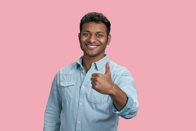 Joven sonriente hombre del sur de Asia mostrando un pulgar hacia arriba