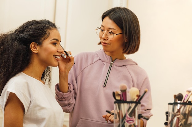 Una joven sonriente con un maquillador