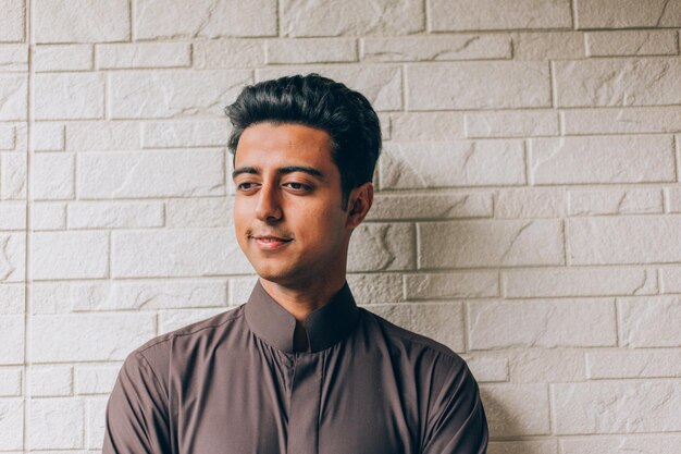 Foto un joven sonriente mirando hacia la pared.