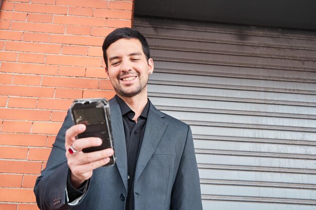 joven sonriente mirando su teléfono inteligente