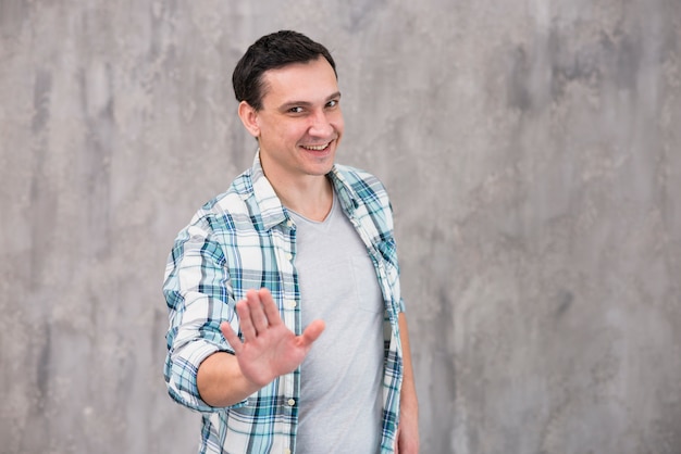 Foto joven sonriente mostrando parada gesto