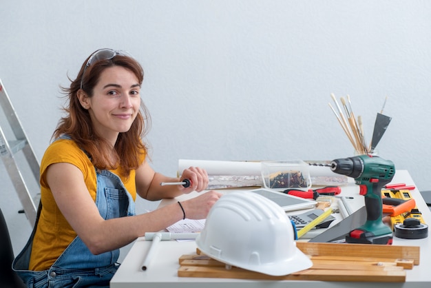 Joven sonriente mujer arquitecto en la oficina