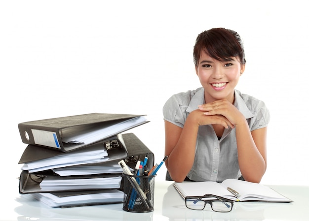 Joven sonriente mujer de negocios trabajando en su papeleo