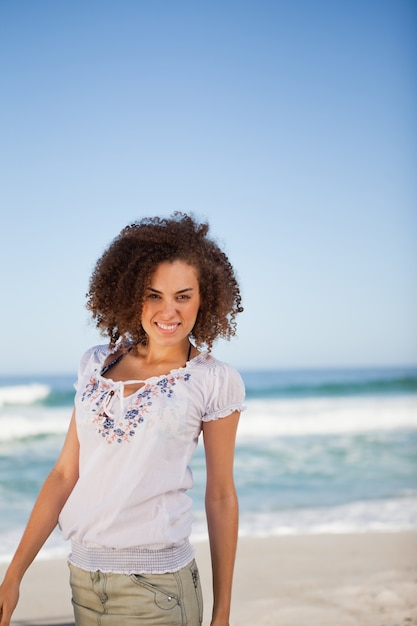 Joven sonriente, de pie en la playa