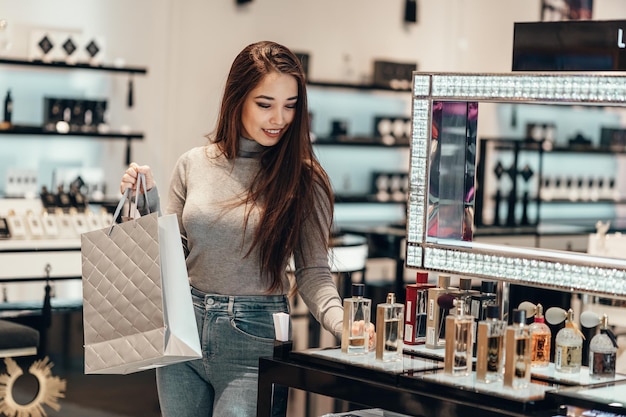 Una joven sonriente de pie en una tienda de perfumes