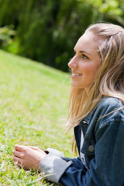 Joven sonriente, tirado en el pasto en el campo