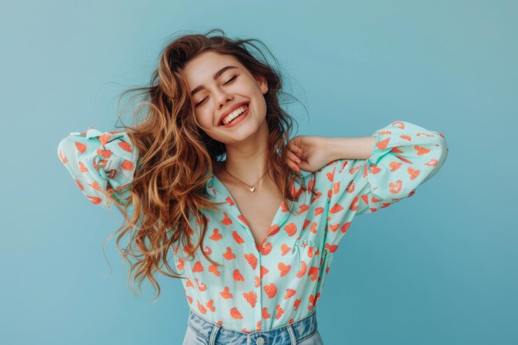 Una joven sonriente con un traje colorido posando alegremente contra un fondo azul vibrante