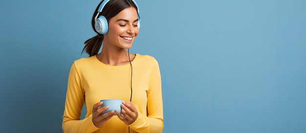 Joven sonriente con traje de yoga azul y auriculares blancos posando para comprar en línea