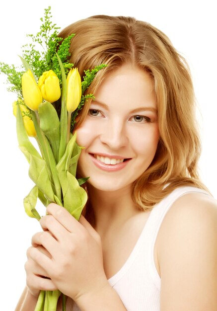 Joven sonriente con tulipanes amarillos