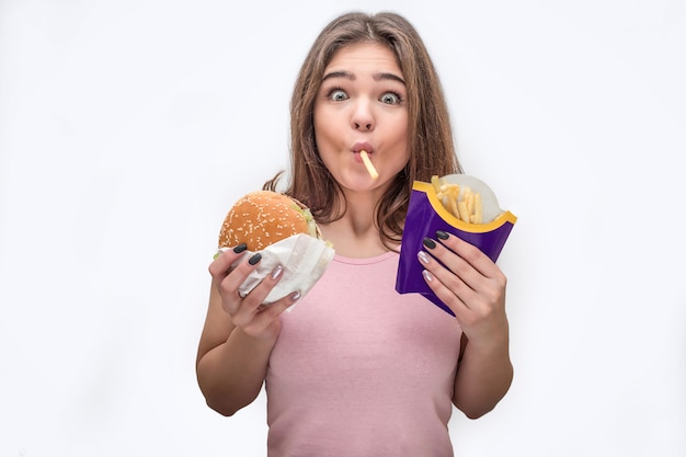 Joven sorprendida mira a la cámara y come papas fritas