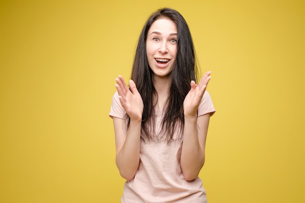 Joven sorprendida en pared amarilla