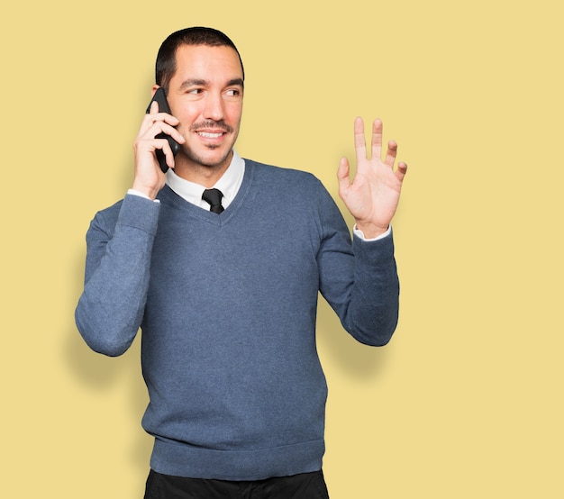 Joven sorprendido apuntando y usando su teléfono móvil