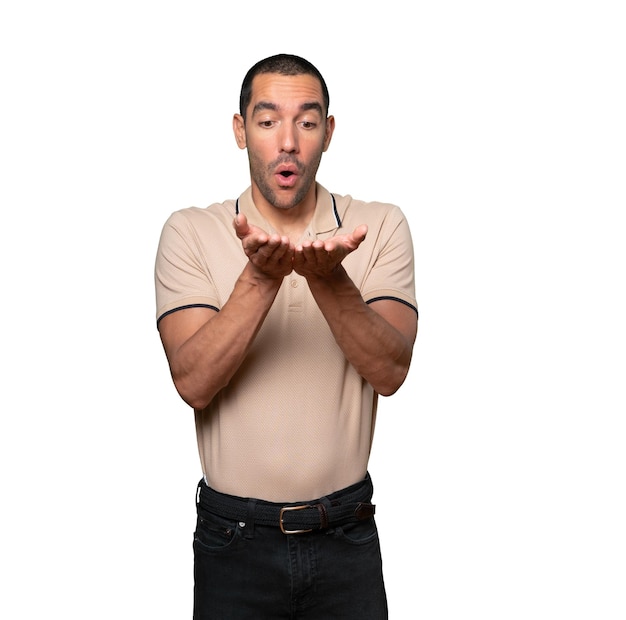 Joven sorprendido sosteniendo algo con la mano