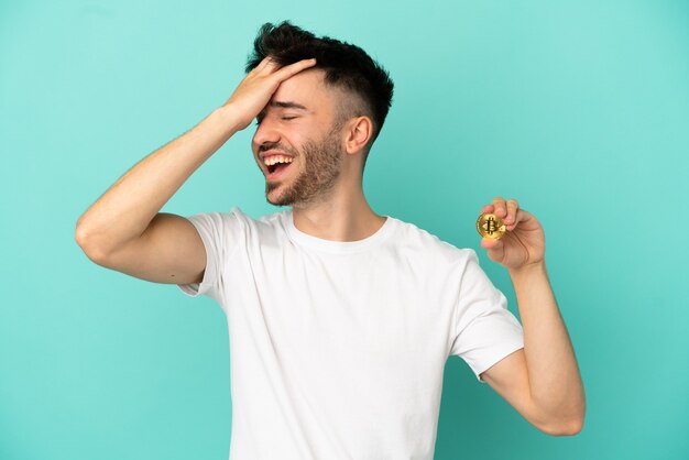 Joven sosteniendo un Bitcoin aislado sobre fondo azul se ha dado cuenta de algo y tiene la intención de la solución