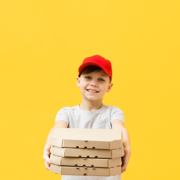 Joven sosteniendo cajas de pizzas