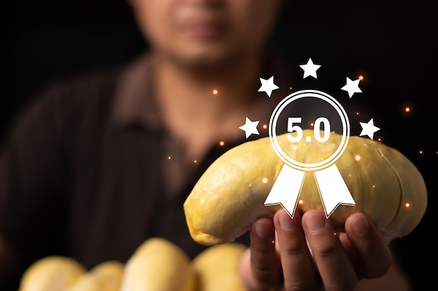 Joven sosteniendo durian, que es la fruta nacional de Tailandia Five Star Rating