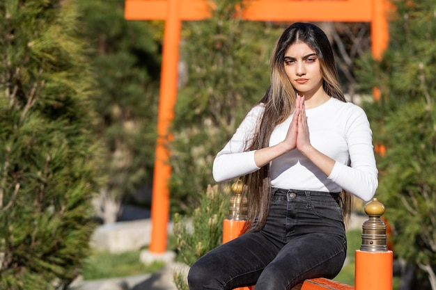 Una joven sosteniendo las manos juntas y rezando Foto de alta calidad