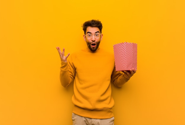 Joven sosteniendo palomitas celebrando una victoria o éxito