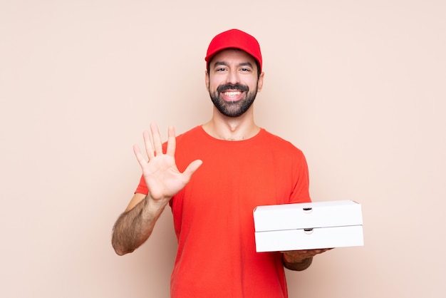 Joven sosteniendo una pizza contando cinco con los dedos