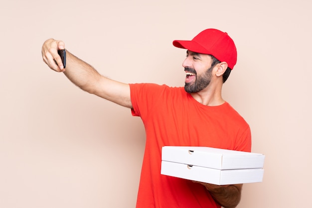 Foto joven sosteniendo una pizza haciendo un selfie