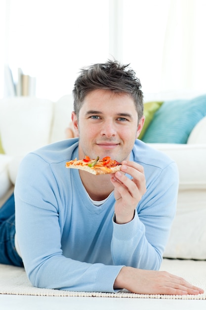 Un joven sosteniendo una pizza