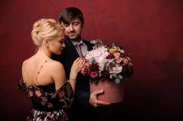 Joven sosteniendo un ramo de flores cerca de su mujer