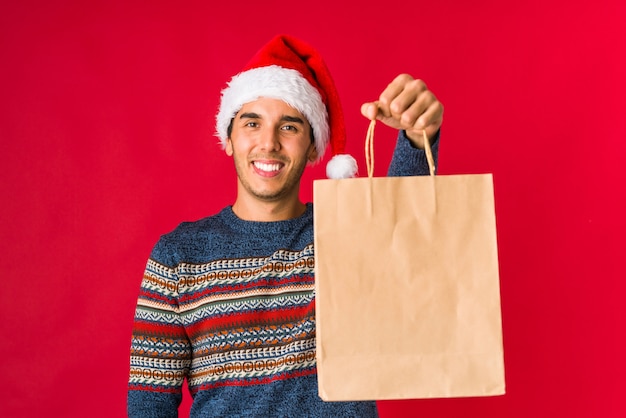 Joven sosteniendo un regalo el día de Navidad