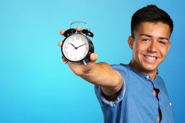 Joven sosteniendo un reloj despertador