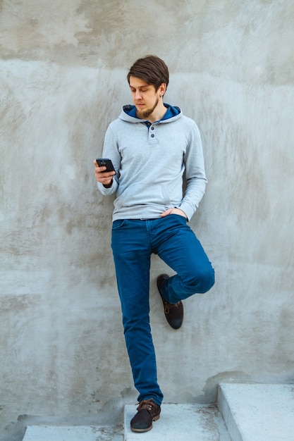 Joven sosteniendo un teléfono en las manos