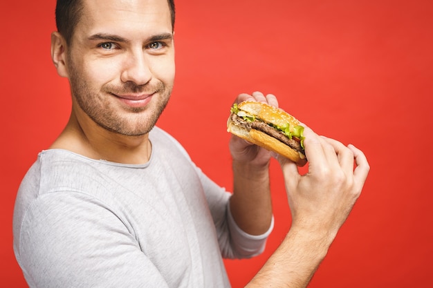 Foto joven sosteniendo un trozo de hamburguesa