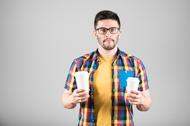 Joven sosteniendo vasos de papel aislado