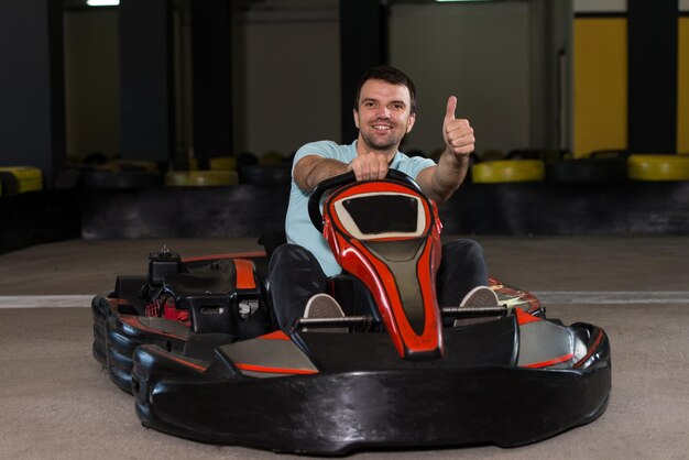 Foto joven sostiene una carrera de karting de velocidad de copa