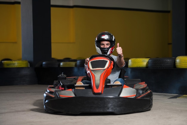 Foto joven sostiene una carrera de karting de velocidad de copa