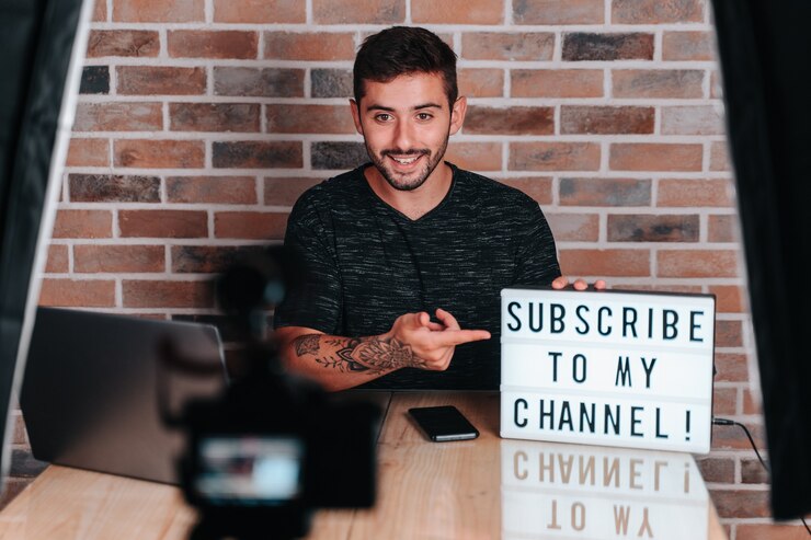 Foto un joven streamer de unos 20 años hablando sobre tecnología mientras le dice que vive para suscribirse