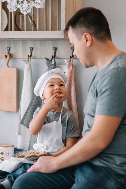 Joven y su hijo cocinando en la cocina