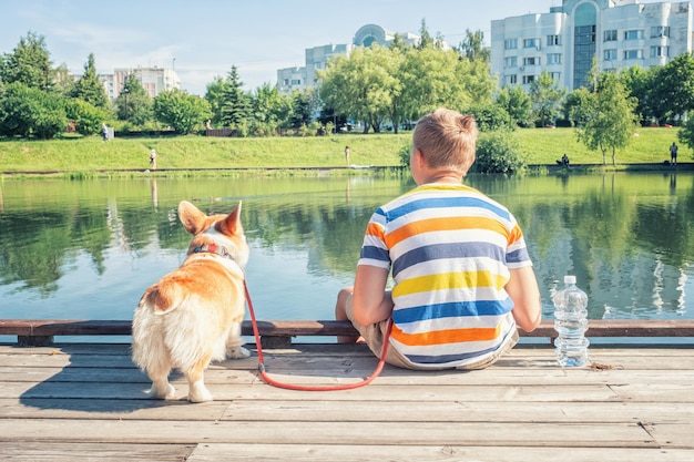 Joven y su perro mascota en un par de madera