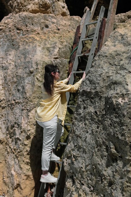 Foto una joven sube las escaleras en la roca