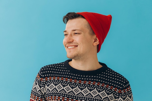 Joven en suéter y sombrero de Navidad en color backgroundxA