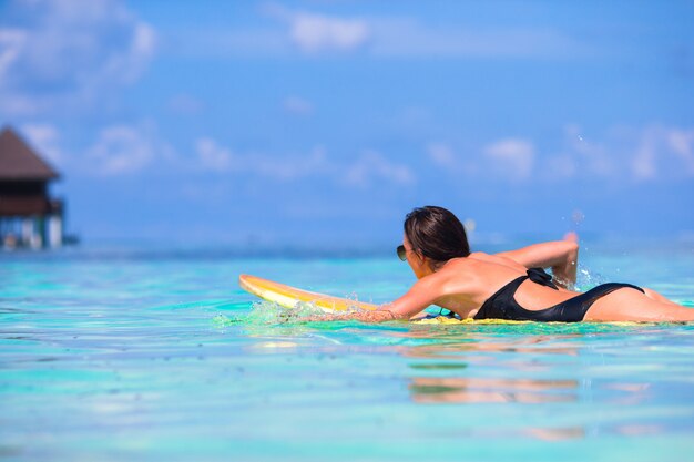 Joven surfista surfeando durante vacaciones en la playa