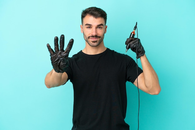 Joven tatuador hombre aislado de fondo azul feliz y contando cuatro con los dedos