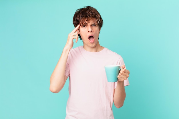 Joven con una taza de café que parece sorprendido, dándose cuenta de un nuevo pensamiento, idea o concepto