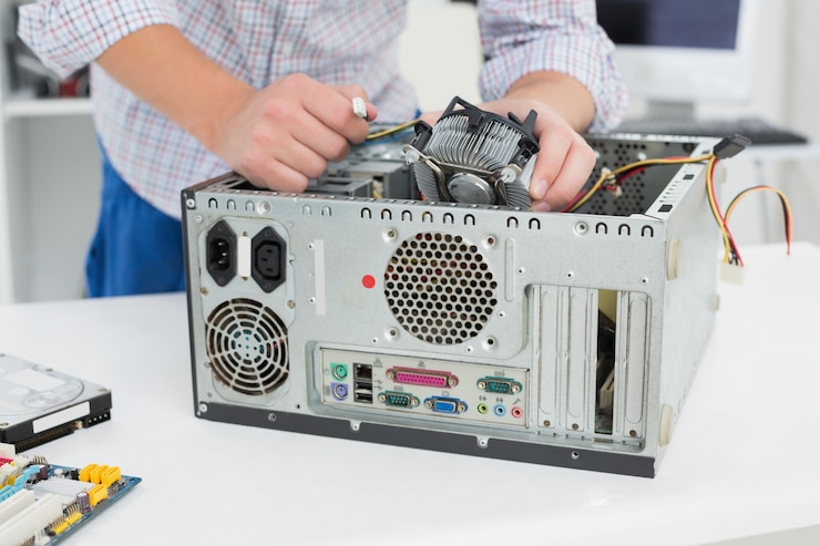 Foto joven técnico que trabaja en la computadora rota