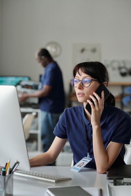 Joven técnico con el teléfono inteligente por el oído