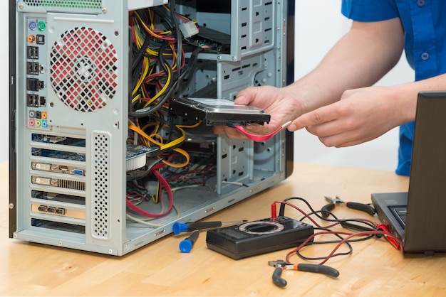 Joven técnico trabajando en computadora rota en su oficina