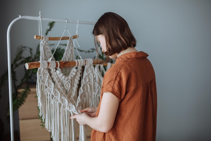 Foto una joven teje paneles de macrame en casa