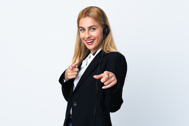 La joven telemarketer sobre puntos blancos aislados te señala con una expresión de confianza