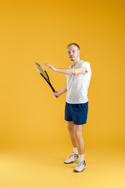 Joven tenista juega al tenis en un amarillo